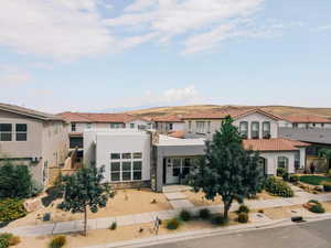 Mediterranean / spanish-style house with stucco siding, a residential view, and stone siding