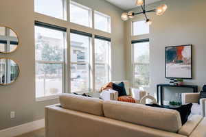 Living area featuring baseboards and a chandelier