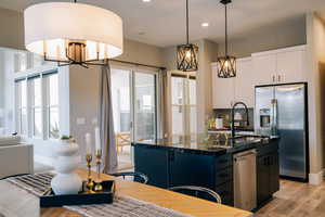 Kitchen featuring stainless steel appliances, hanging light fixtures, light wood-style flooring, healthy amount of natural light, and recessed lighting
