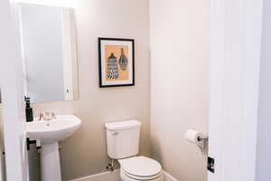 Half bathroom featuring toilet and baseboards