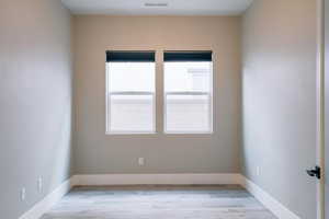 Spare room with light wood-style flooring and baseboards