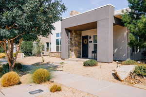 View of front of house with stone siding, stucco siding, and a chimney