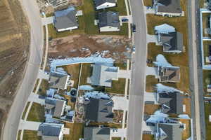 Aerial view of property and surrounding area with nearby suburban area