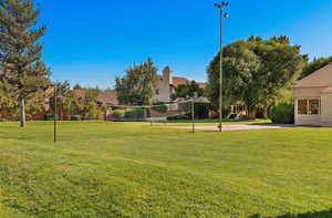 View of community featuring a lawn and volleyball court