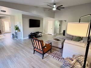 Living area with light wood-type flooring and a ceiling fan