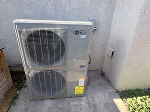 Exterior view of stucco siding and an ac unit
