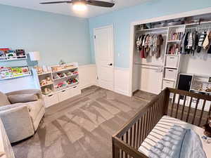 Bedroom with a closet, light carpet, and a ceiling fan
