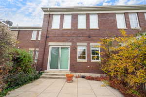 Back of house with entry steps and brick siding