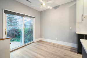 Unfurnished dining area with light wood-type flooring and a ceiling fan