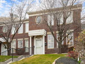 View of front of home with brick siding and a front yard