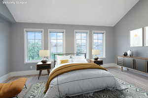 Bedroom featuring lofted ceiling and wood finished floors