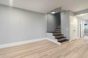 Stairs featuring wood finished floors and baseboards