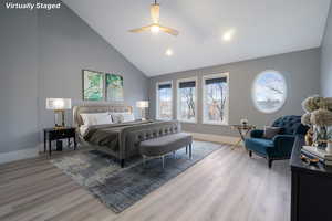 Bedroom featuring high vaulted ceiling, light wood-style floors, multiple windows, and a ceiling fan