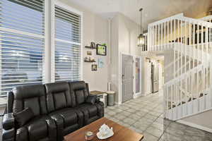 Living area with stairway and a high ceiling