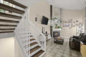 Staircase with a glass covered fireplace and a towering ceiling