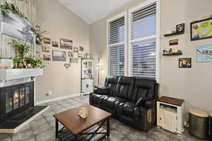 Living area with a glass covered fireplace and high vaulted ceiling