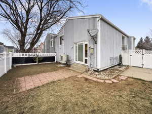 Back of property with a fenced backyard, a gate, a patio area, and entry steps