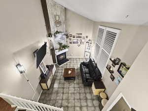 Living room featuring a glass covered fireplace and a high ceiling
