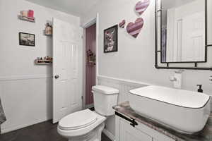 Bathroom with vanity and a wainscoted wall