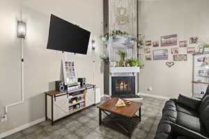 Living area with a glass covered fireplace and a high ceiling