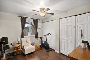 Living area with dark wood-type flooring and ceiling fan