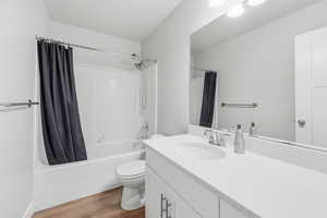 Full bath with light wood-type flooring, vanity, and shower / bathtub combination with curtain
