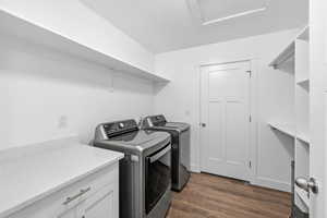 Laundry area featuring dark wood-style flooring and washer and dryer