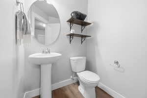 Bathroom with toilet and wood finished floors