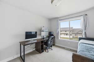 Office space with light colored carpet and baseboards