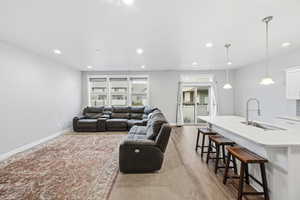 Living area with light wood-style flooring and recessed lighting