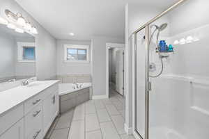 Bathroom with a shower stall, a garden tub, vanity, light tile patterned floors, and recessed lighting