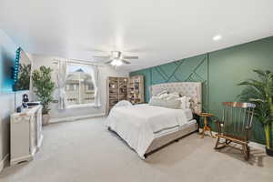 Carpeted bedroom with an accent wall, ceiling fan, and recessed lighting