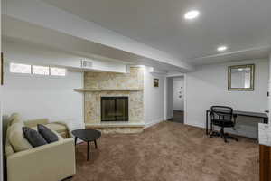 Living room with a fireplace, a desk, carpet, and recessed lighting