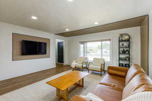 Living room featuring wood finished floors, recessed lighting, and a textured ceiling