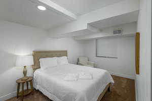 Bedroom featuring dark colored carpet and baseboards