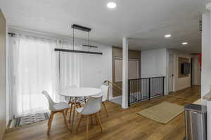 Dining space featuring wood finished floors, recessed lighting, and a textured ceiling
