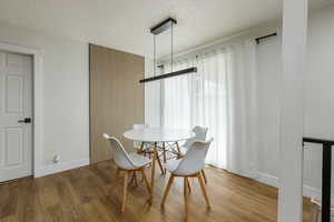 Dining area with a textured ceiling and wood finished floors