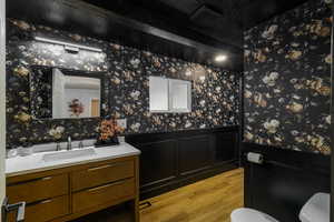 Bathroom with wallpapered walls and vanity