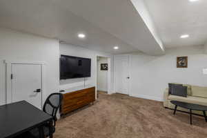 Office area featuring dark carpet, a textured ceiling, and recessed lighting