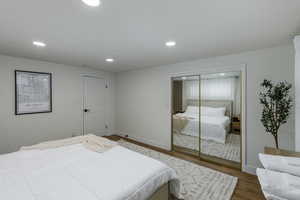Bedroom with wood finished floors, a closet, and recessed lighting