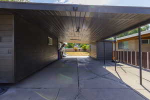 View of patio / terrace featuring an attached carport and an outdoor structure