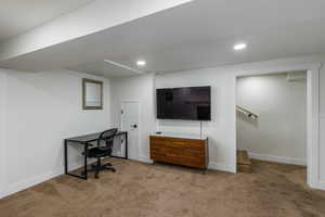 Carpeted office space featuring baseboards and recessed lighting