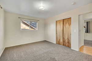 Unfurnished bedroom with light colored carpet and a closet