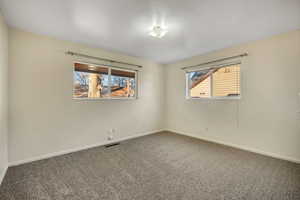 Carpeted empty room featuring baseboards