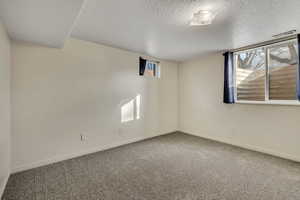 Spare room featuring carpet flooring and a textured ceiling