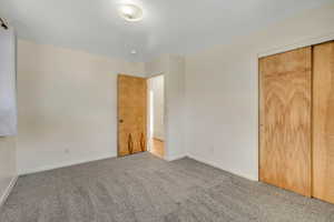Unfurnished bedroom featuring carpet flooring and a closet