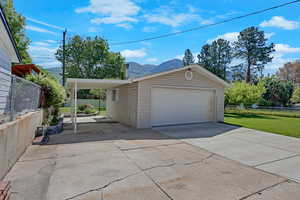 Garage with a mountain view, a carport, and driveway