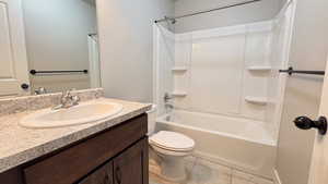 Full bath with  shower combination, vanity, and light tile patterned flooring