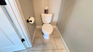 Bathroom with toilet and light tile patterned floors