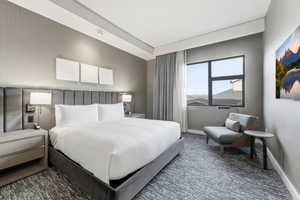 Bedroom featuring dark colored carpet and baseboards